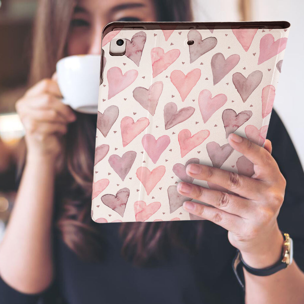 a girl is holding and viewing personalized iPad folio case with Love design